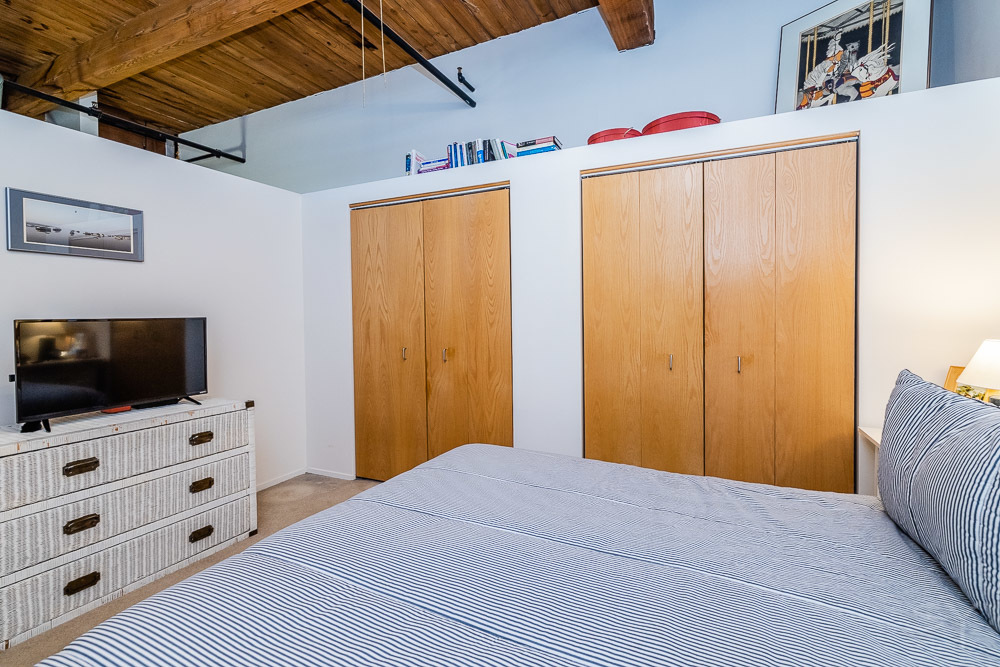 1250 West Van Buren Street, Unit 703 Chicago, IL 60607 - Photo 5 of 18 a bedroom with a bed and a flat screen tv
