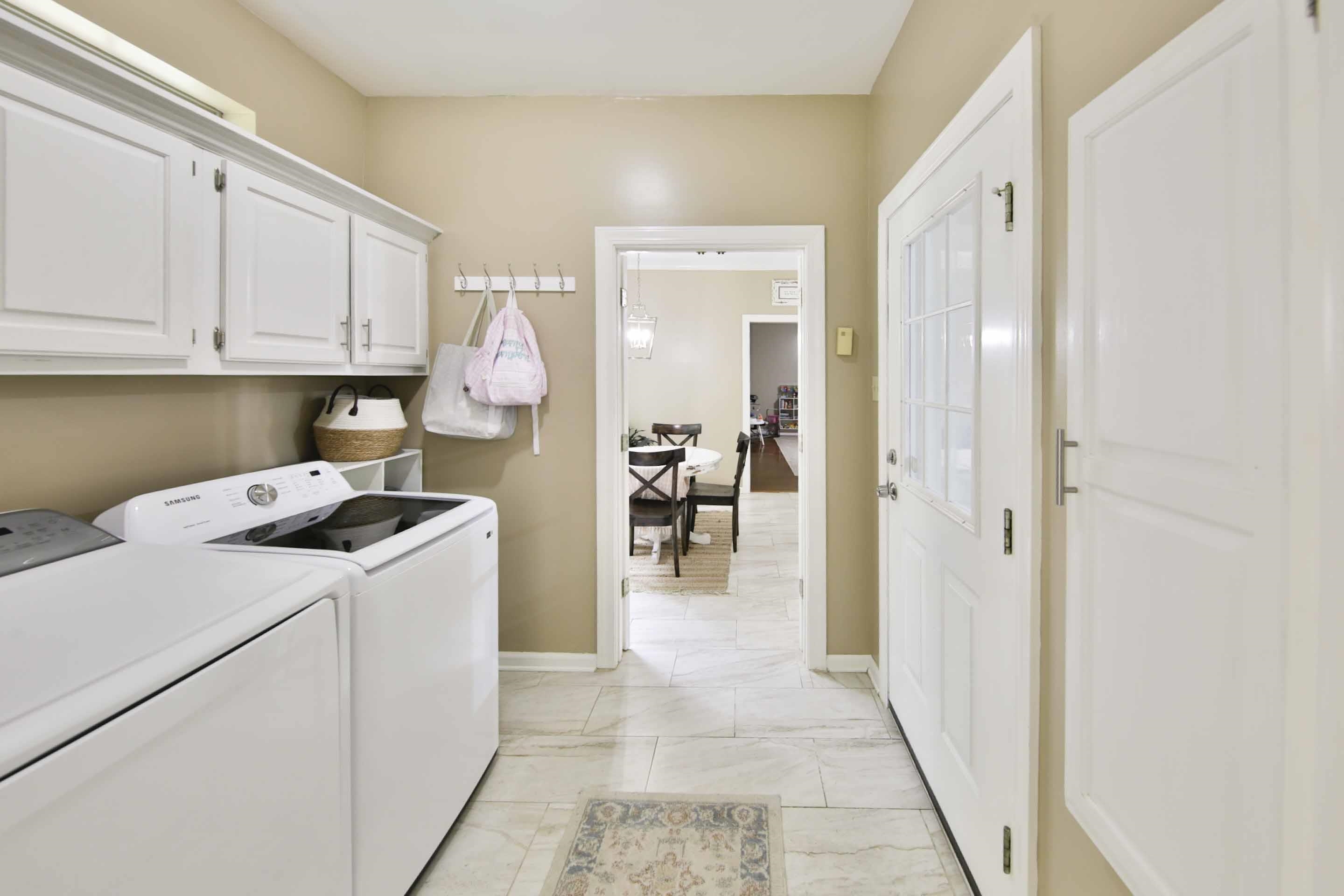 104 Miller Road Covington, TN 38019 - Photo 15 of 25 Laundry area featuring white cabinetry, tile flooring, and a glass-paneled door