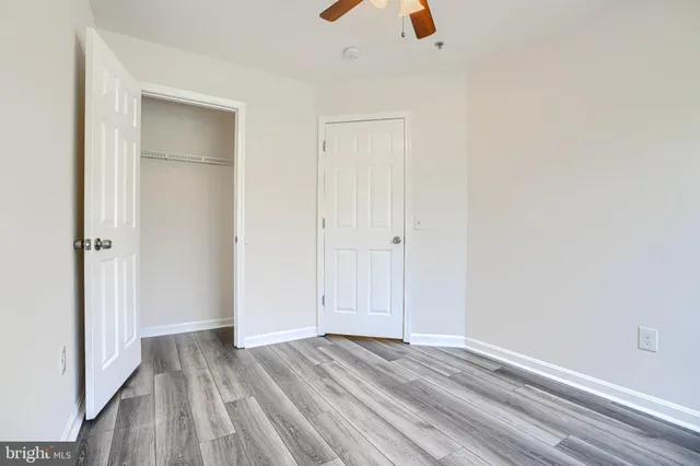 an empty room with wooden floor and closet