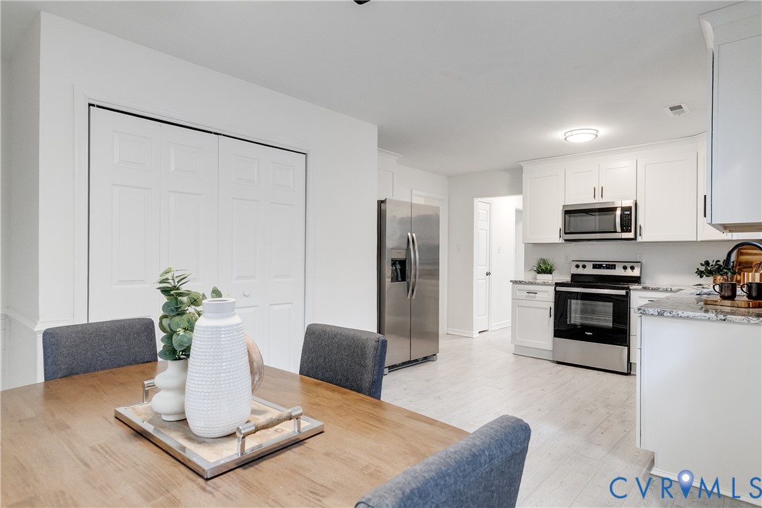 10008 Brittonwood Drive North Chesterfield, VA 23237 - Photo 9 of 34 a kitchen with stainless steel appliances granite countertop a refrigerator a stove a sink a dining table and chairs