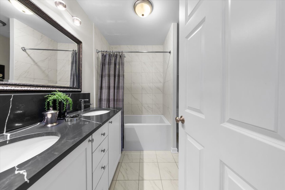 1802 North Spaulding Avenue Chicago, IL 60647 - Photo 16 of 28 a bathroom with a double vanity sink a mirror and a bathtub