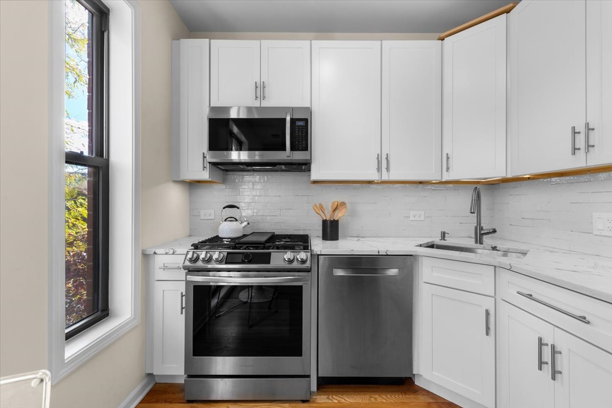 1802 North Spaulding Avenue Chicago, IL 60647 - Photo 4 of 28 a kitchen with stainless steel appliances granite countertop white cabinets and a stove