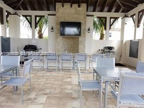 16958 Southwest 92nd Street, Unit 16958 Miami, FL 33196 - Photo 32 of 40 a kitchen with stainless steel appliances kitchen island granite countertop a table and chairs in it