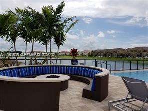 16958 Southwest 92nd Street, Unit 16958 Miami, FL 33196 - Photo 33 of 40 a view of a swimming pool with couches and wooden fence