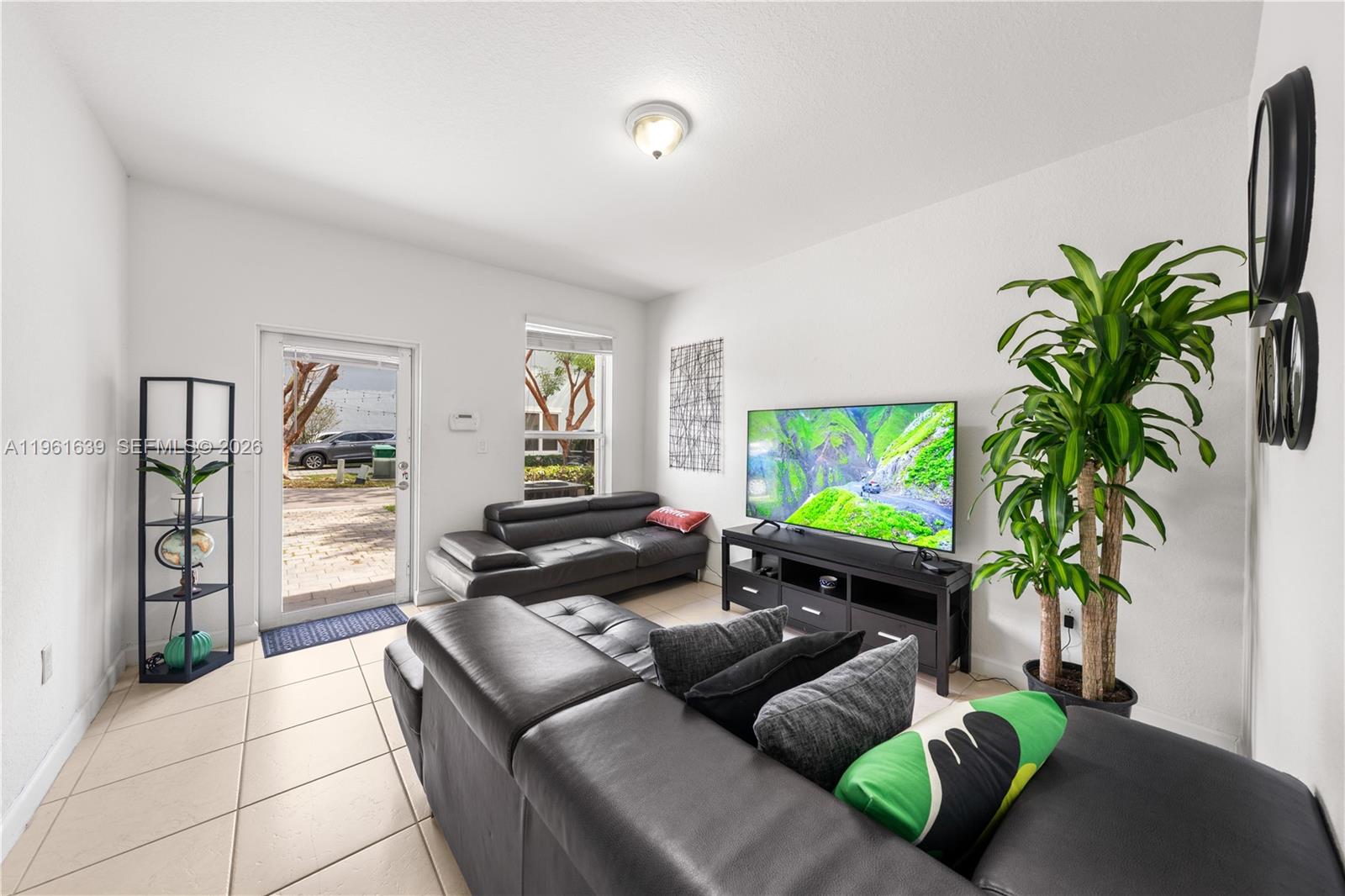 16958 Southwest 92nd Street, Unit 16958 Miami, FL 33196 - Photo 7 of 40 a living room with furniture and a flat screen tv
