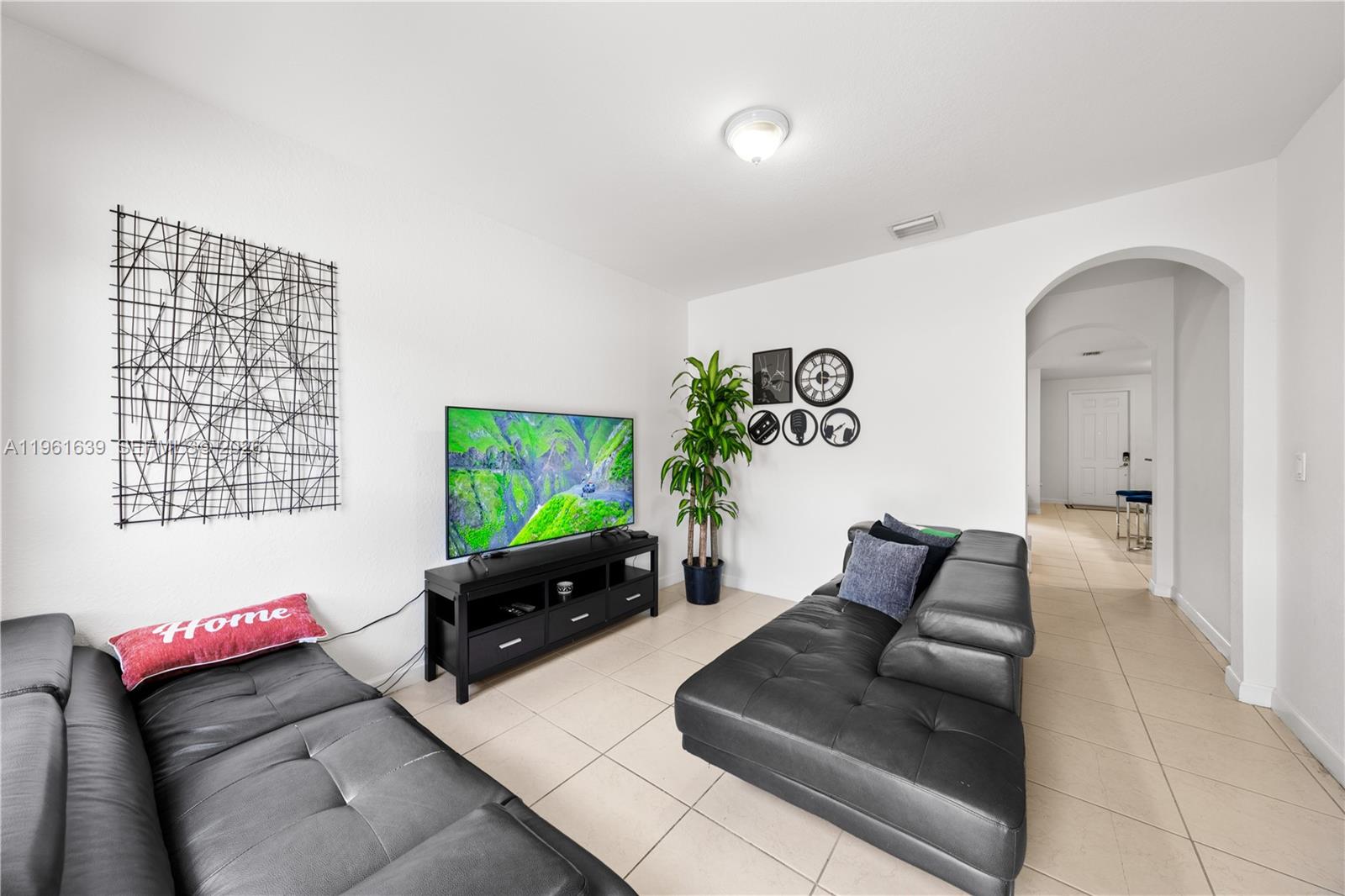 16958 Southwest 92nd Street, Unit 16958 Miami, FL 33196 - Photo 8 of 40 a living room with furniture and a flat screen tv