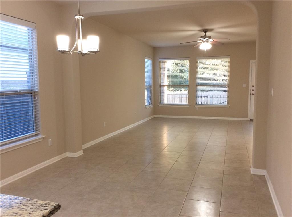 3451 Mayfield Ranch Boulevard, Unit 340 Round Rock, TX 78681 - Photo 4 of 13 A well-lit living area features tiled flooring and ample natural light through multiple windows.