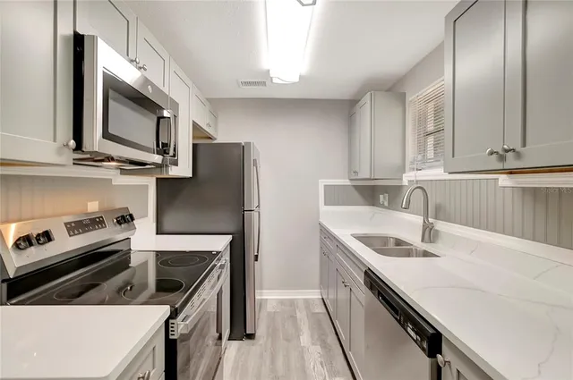a kitchen with stainless steel appliances granite countertop a sink stove and refrigerator