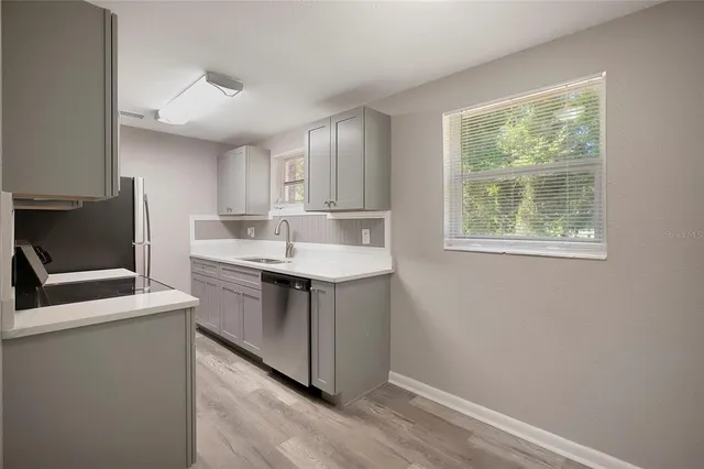 a kitchen with a sink cabinets and window
