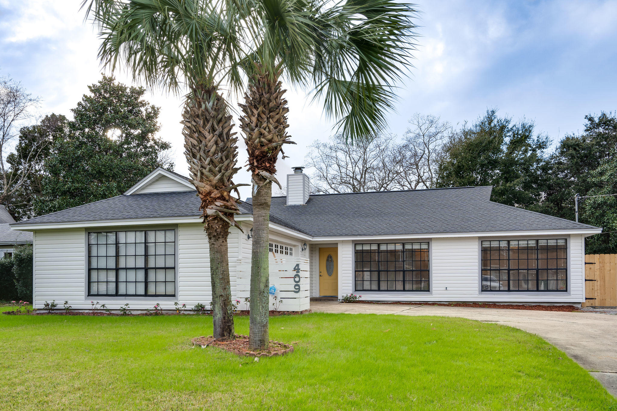 409 Juniper Street Destin, FL 32541 - Photo 1 of 32 front view of a house with a yard and palm trees