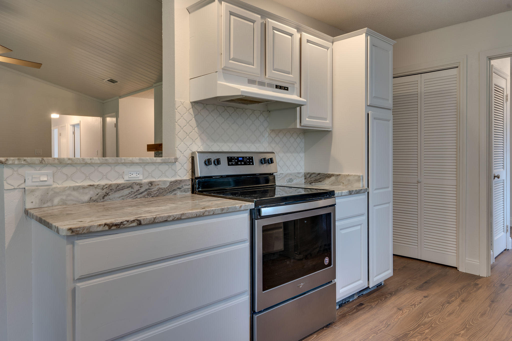 409 Juniper Street Destin, FL 32541 - Photo 11 of 32 a kitchen with granite countertop cabinets stainless steel appliances and wooden floor