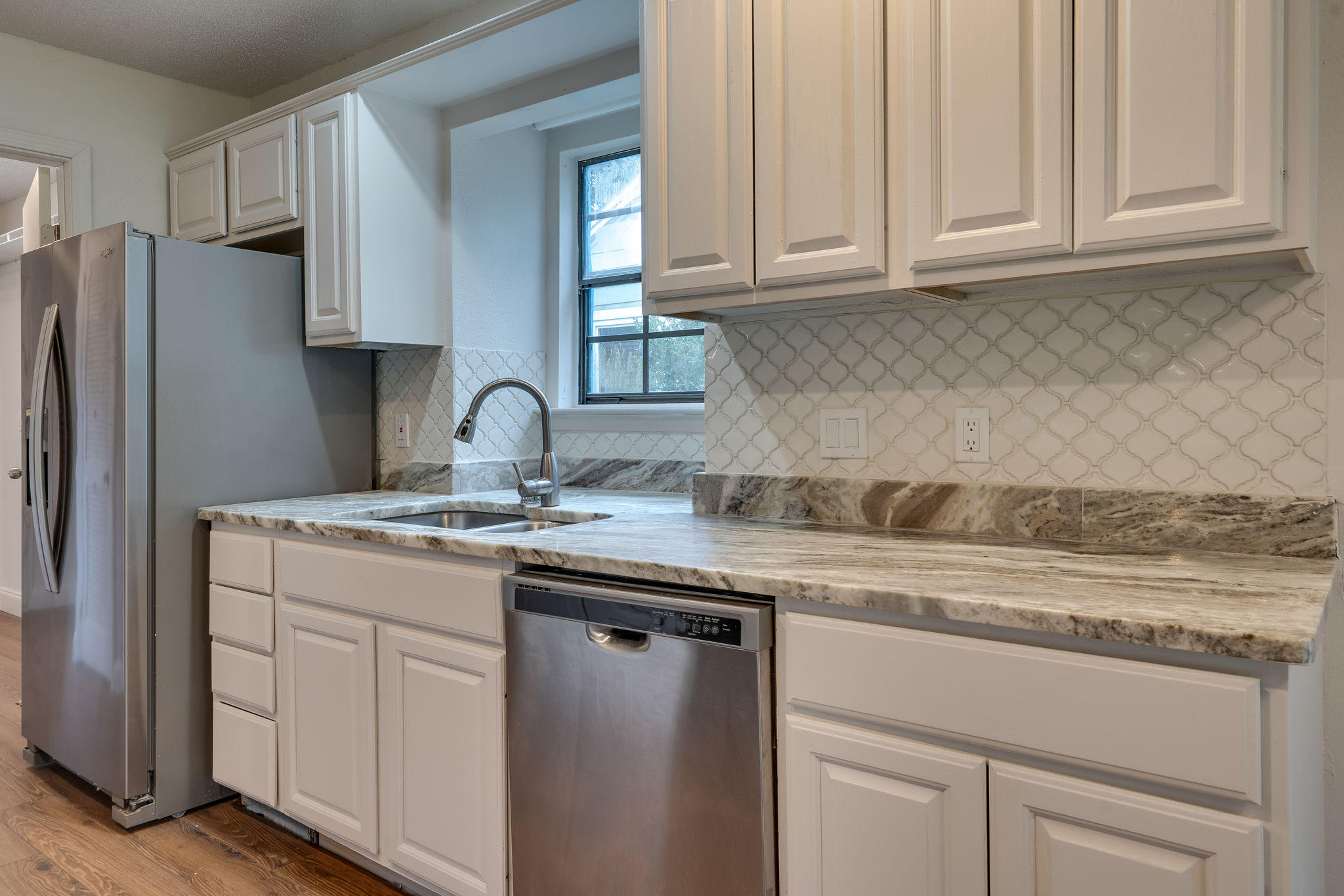 409 Juniper Street Destin, FL 32541 - Photo 12 of 32 a kitchen with stainless steel appliances granite countertop a sink stove and refrigerator