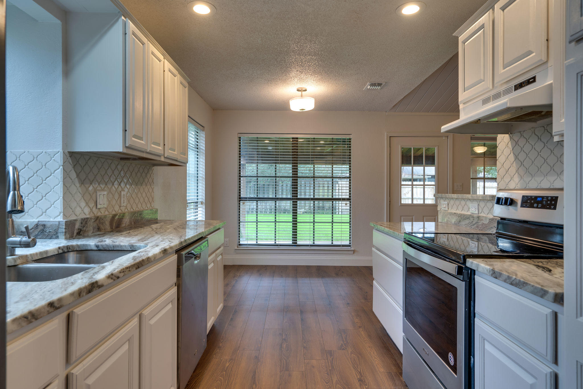 409 Juniper Street Destin, FL 32541 - Photo 13 of 32 a kitchen with stainless steel appliances granite countertop a sink stove and cabinets