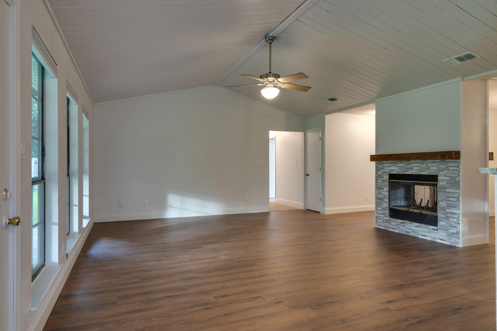 409 Juniper Street Destin, FL 32541 - Photo 16 of 32 an empty room with wooden floor fireplace and windows