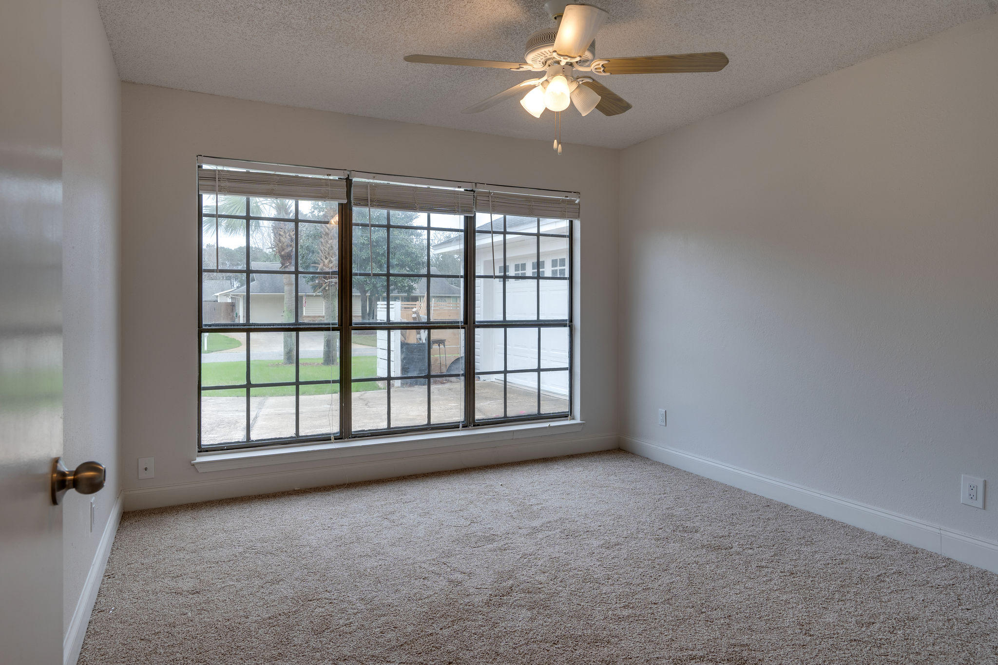 409 Juniper Street Destin, FL 32541 - Photo 18 of 32 an empty room with chandelier fan and windows