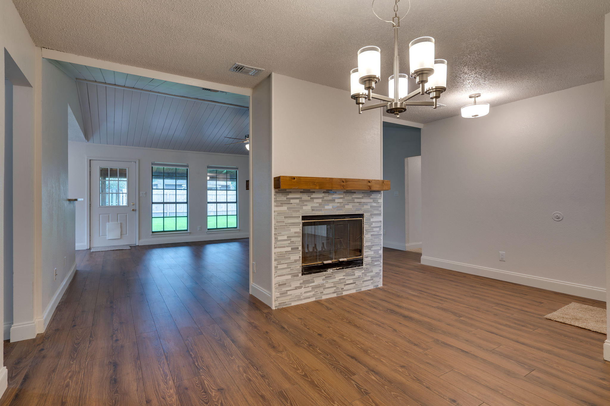 409 Juniper Street Destin, FL 32541 - Photo 5 of 32 a view of a livingroom with a fireplace wooden floor and a chandelier