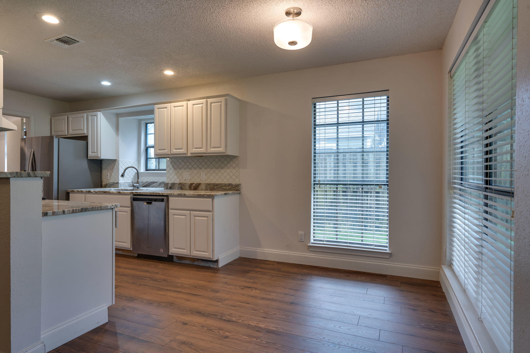 409 Juniper Street Destin, FL 32541 - Photo 9 of 32 a kitchen with granite countertop white cabinets and wooden floor