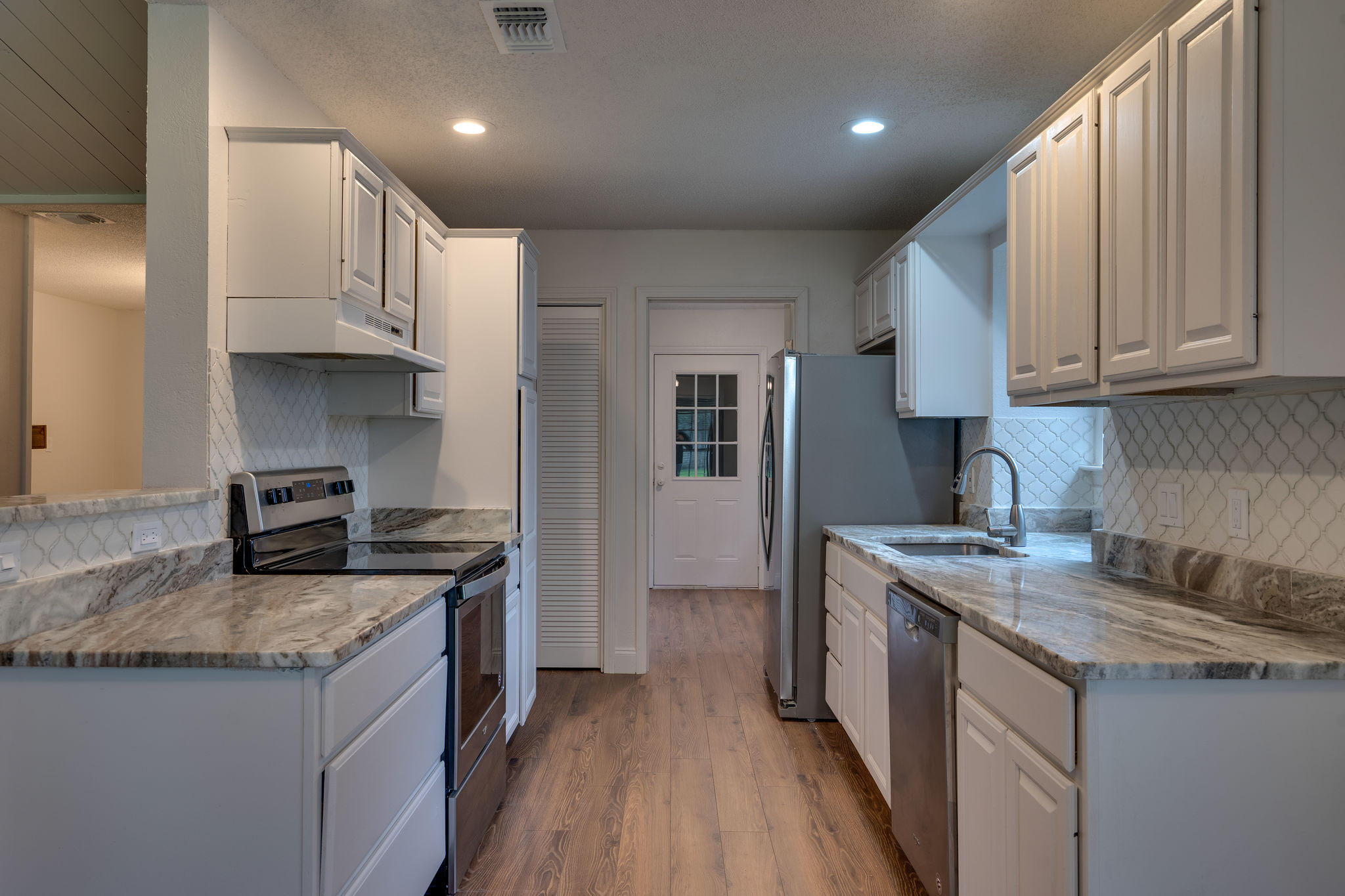 409 Juniper Street Destin, FL 32541 - Photo 10 of 32 a kitchen with granite countertop a sink stove and refrigerator