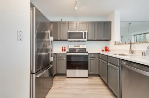 a kitchen with a refrigerator sink and cabinets