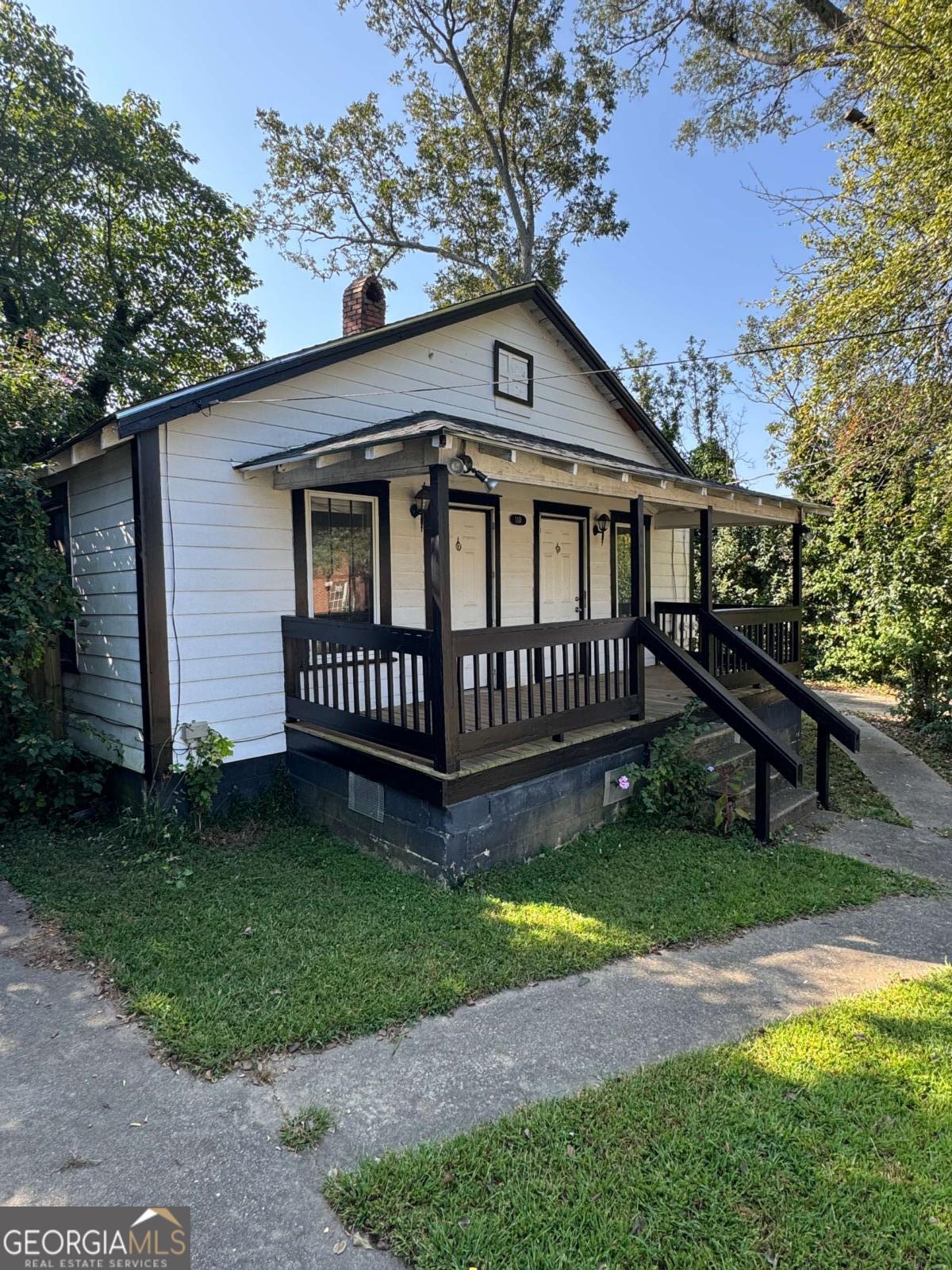 a view of a house with a yard and a wooden deck