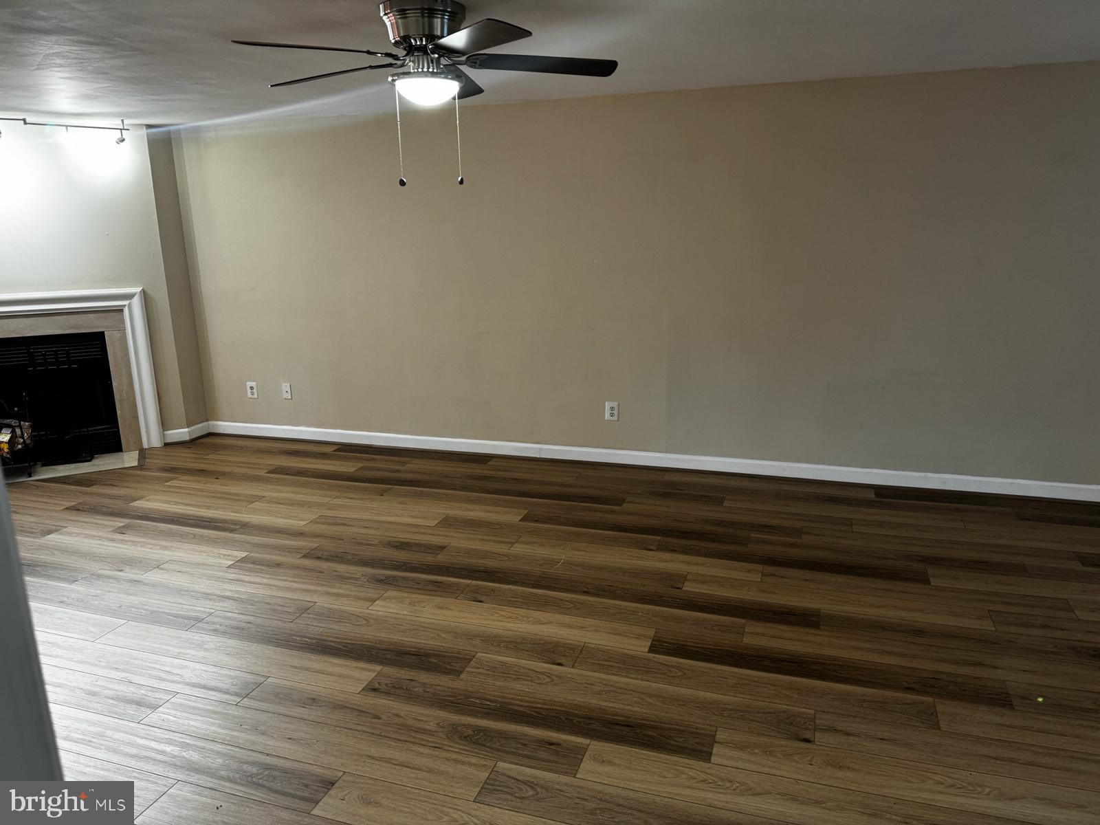21131 Crocus Terrace Ashburn, VA 20147 - Photo 25 of 37 a view of an empty room with wooden floor and a fireplace