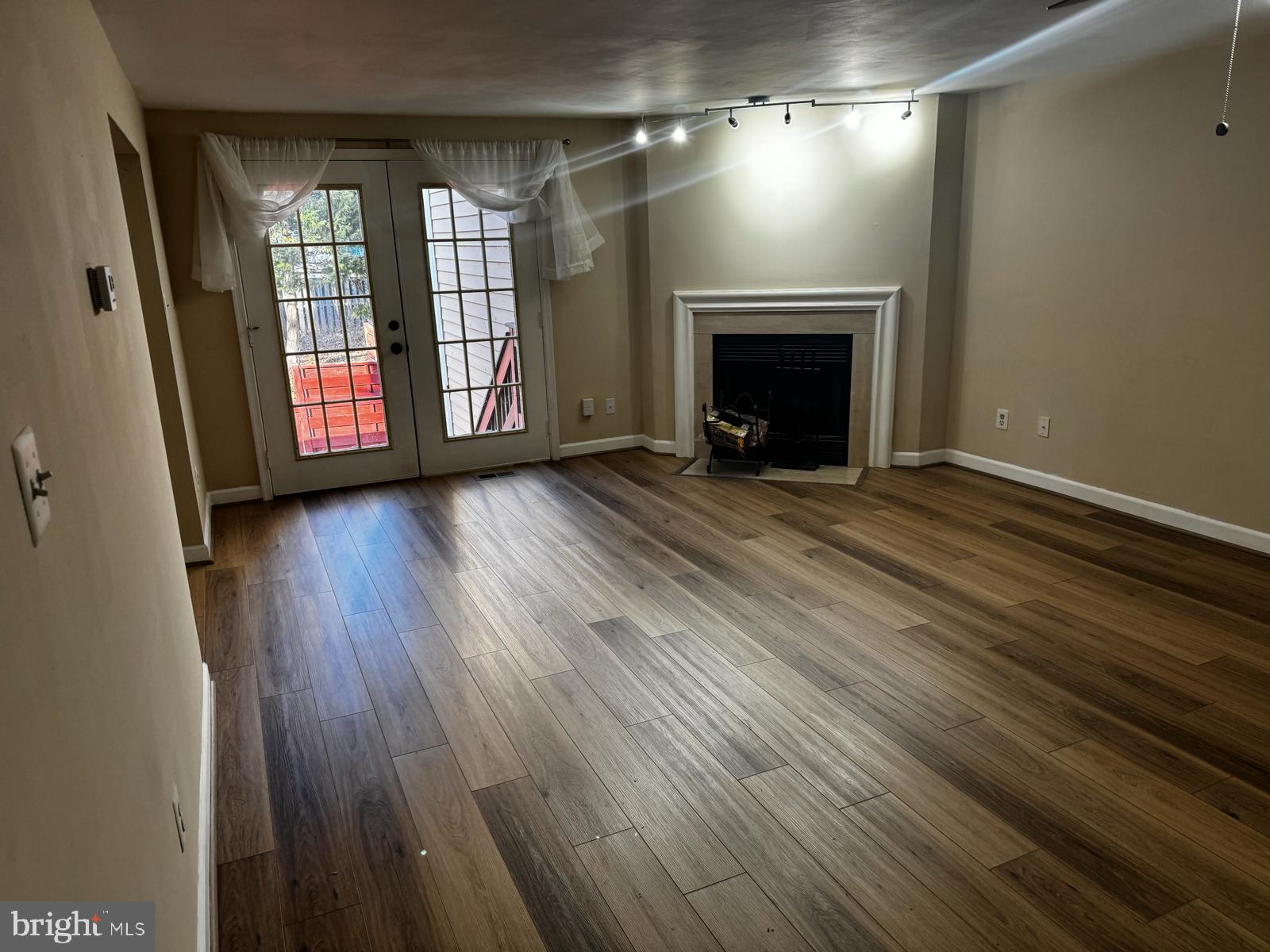 21131 Crocus Terrace Ashburn, VA 20147 - Photo 29 of 37 an empty room with wooden floor fireplace and windows