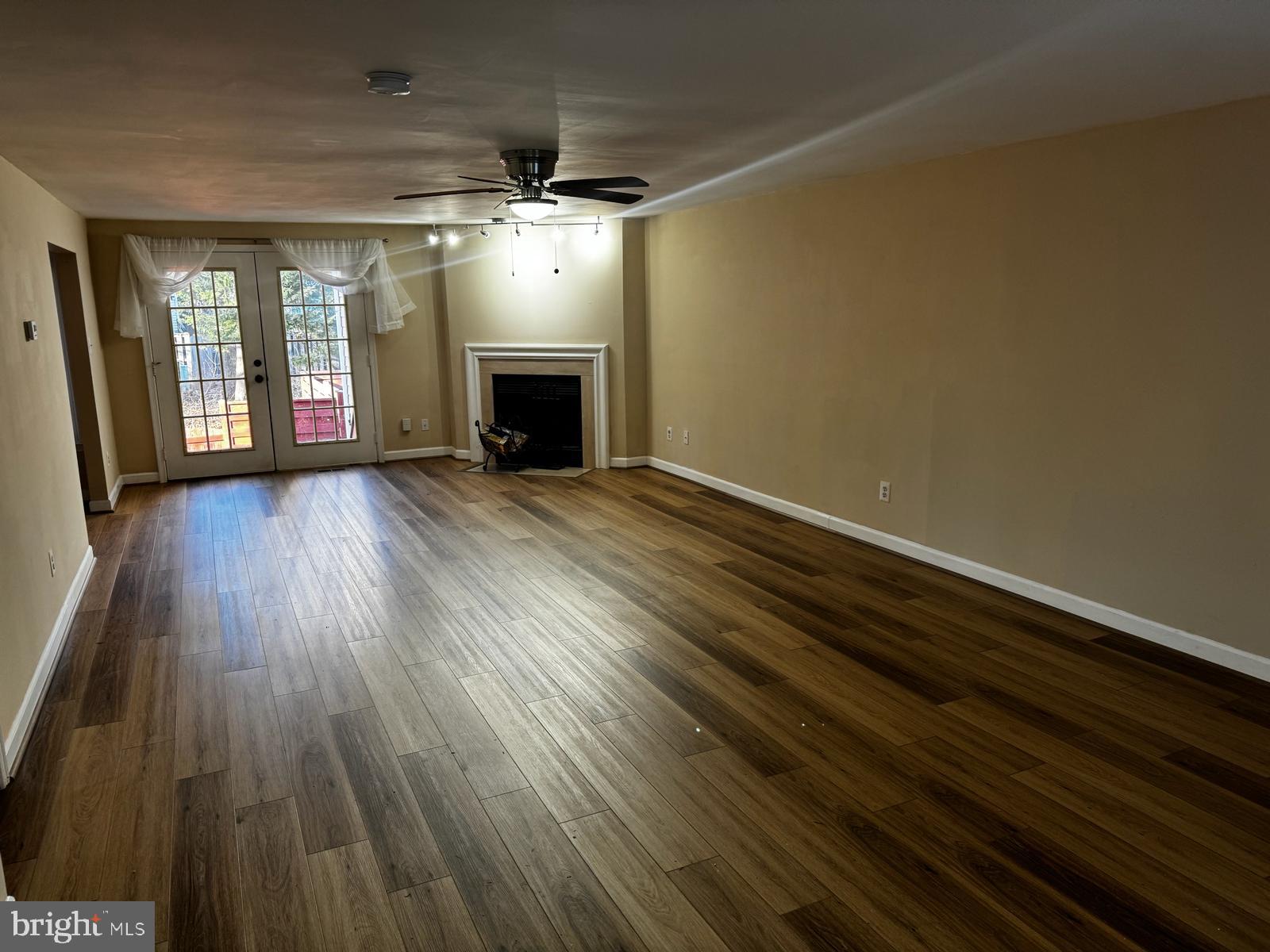 21131 Crocus Terrace Ashburn, VA 20147 - Photo 32 of 37 an empty room with wooden floor fireplace and windows