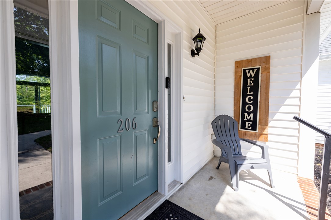 206 Petty Road Seneca, SC 29672 - Photo 4 of 47 A welcoming entry invites with a panel door and charming porch light, highlighting inviting curb appeal.