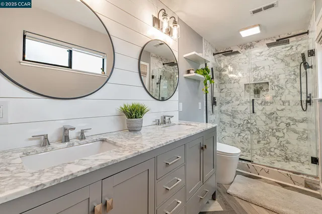 a bathroom with a granite countertop toilet sink and mirror