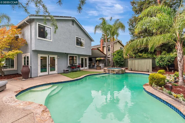 a front view of a house with swimming pool garden and patio