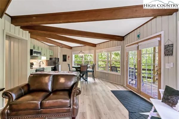 a dining room with furniture a chandelier and wooden floor