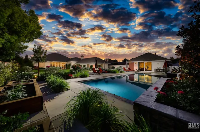 a view of a house with swimming pool and sitting area