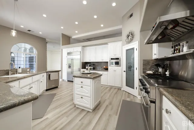 a kitchen with granite countertop a stove a sink dishwasher and a refrigerator