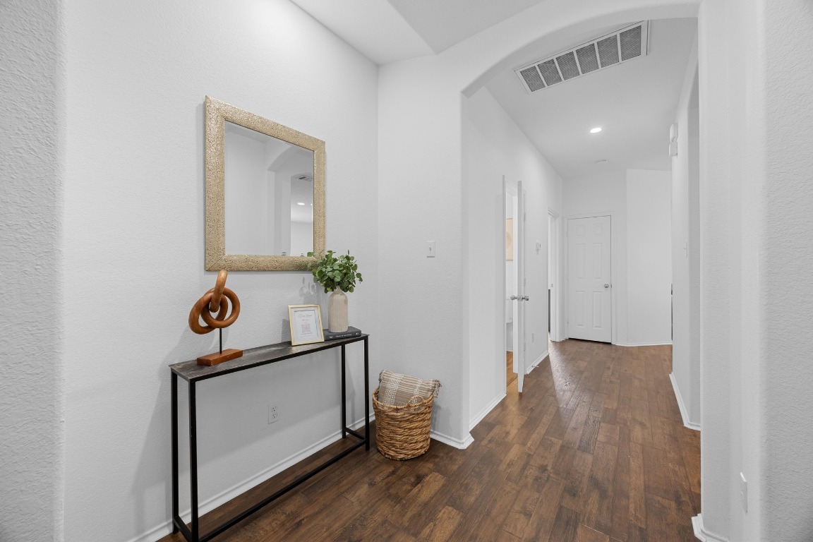 3612 Raven Caw Pass Pflugerville, TX 78660 - Photo 11 of 40 a hallway with painting on the wall and a potted plant