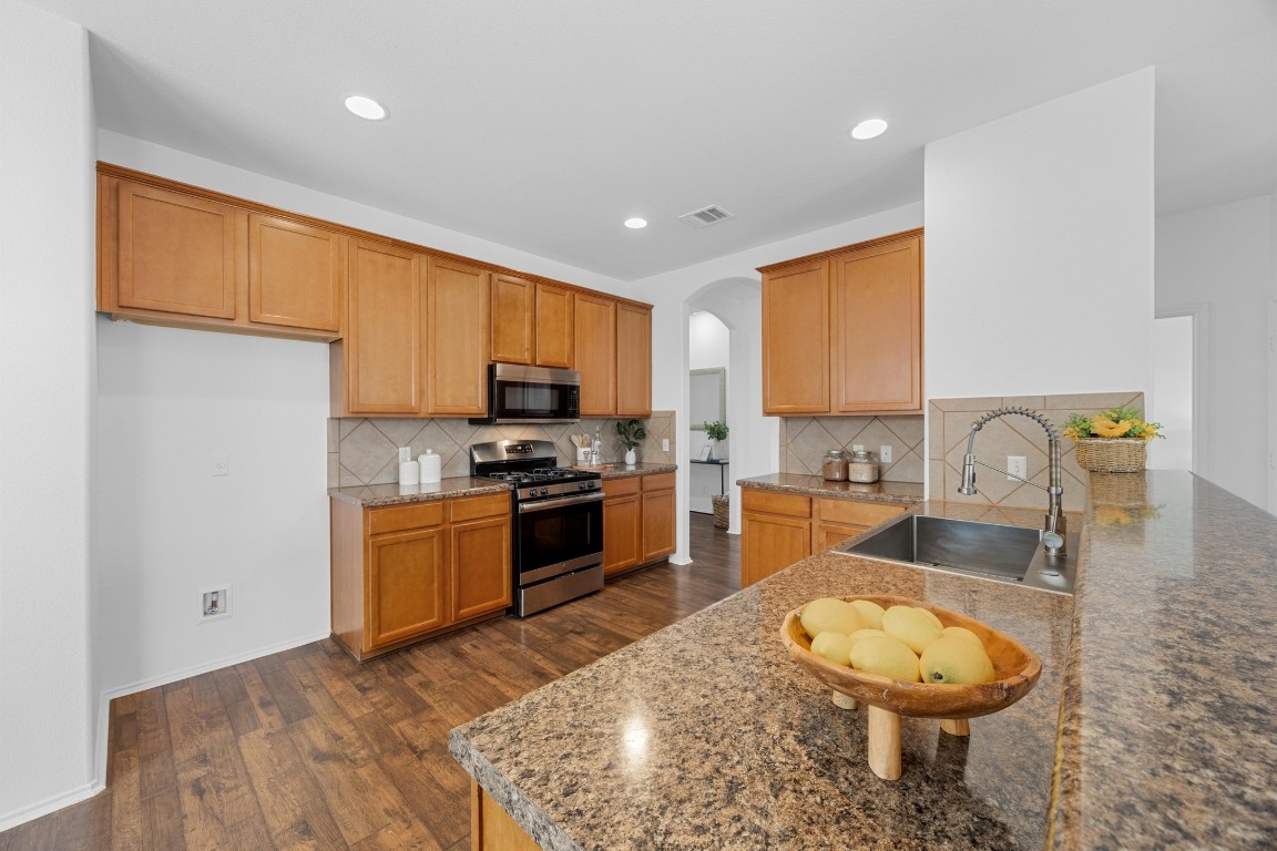 3612 Raven Caw Pass Pflugerville, TX 78660 - Photo 14 of 40 a kitchen with granite countertop a sink stainless steel appliances and cabinets