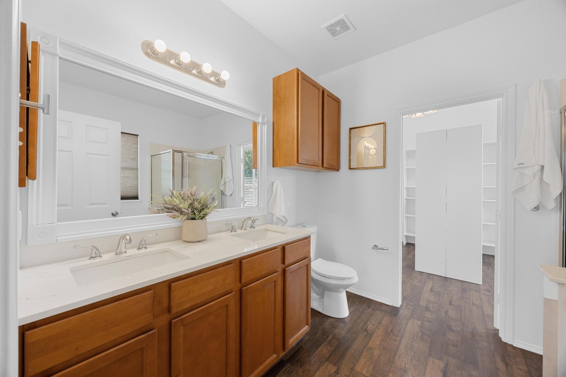 3612 Raven Caw Pass Pflugerville, TX 78660 - Photo 22 of 40 a bathroom with a sink a toilet a mirror and vanity