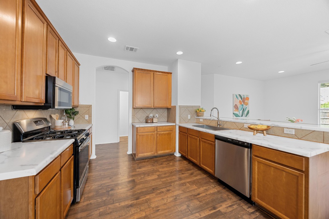 3612 Raven Caw Pass Pflugerville, TX 78660 - Photo 6 of 40 a large kitchen with stainless steel appliances granite countertop a sink and cabinets