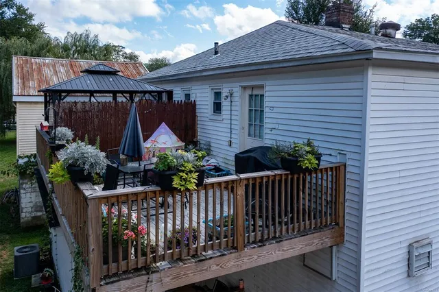a view of a house with wooden fence and potted plants