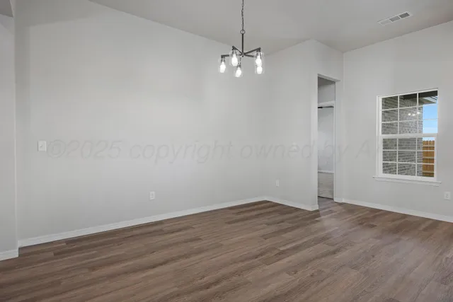 a view of a room with wooden floor and window