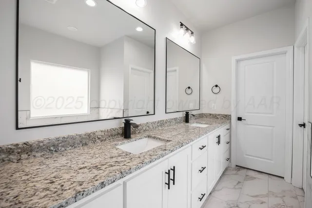 a bathroom with a granite countertop sink and a mirror