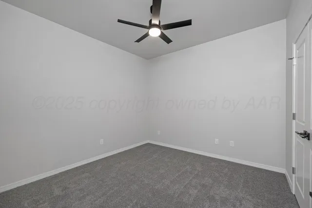 an empty room with a ceiling fan and a window