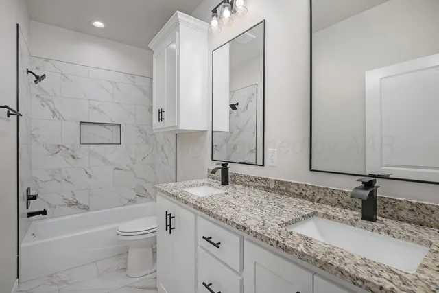a bathroom with a granite countertop sink toilet and shower