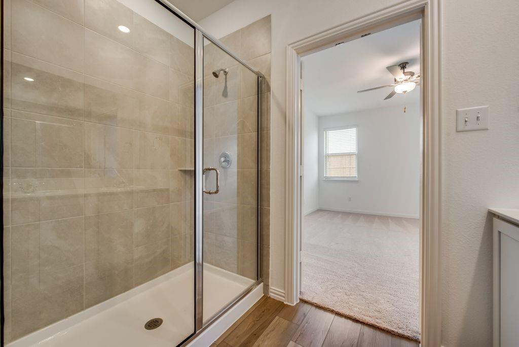 204 Coconut Drive Azle, TX 76020 - Photo 18 of 20 a bathroom with a glass shower door and a mirror