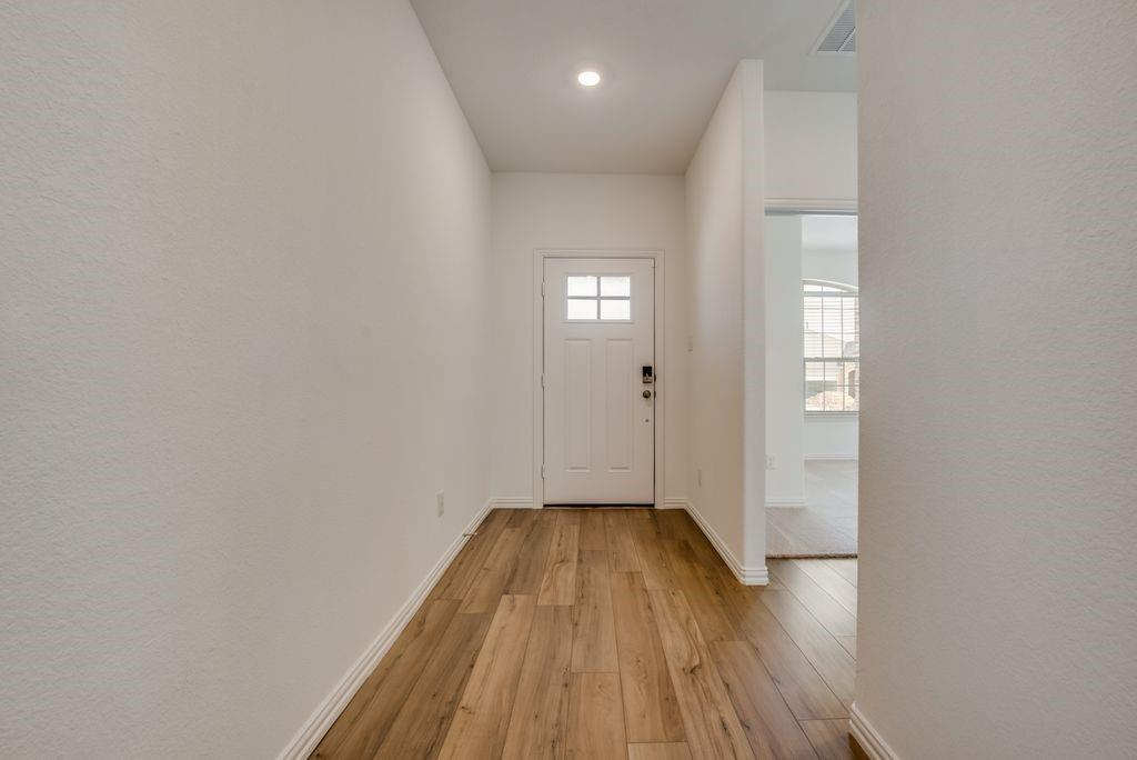 204 Coconut Drive Azle, TX 76020 - Photo 2 of 20 a view of a hallway with wooden floor