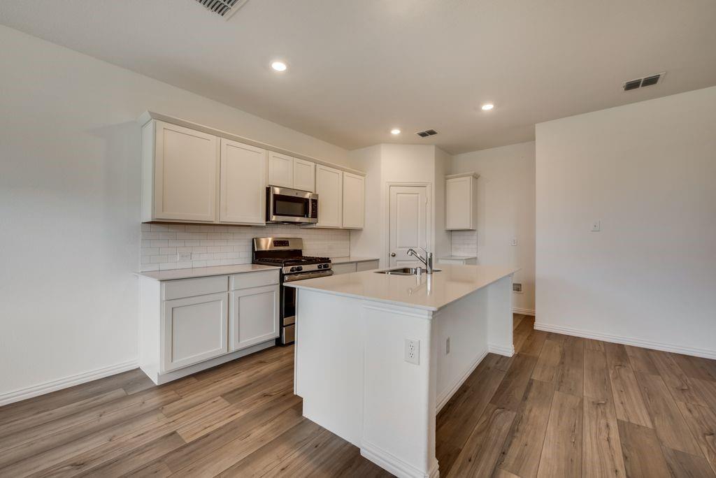 204 Coconut Drive Azle, TX 76020 - Photo 3 of 20 a kitchen with appliances a sink and cabinets