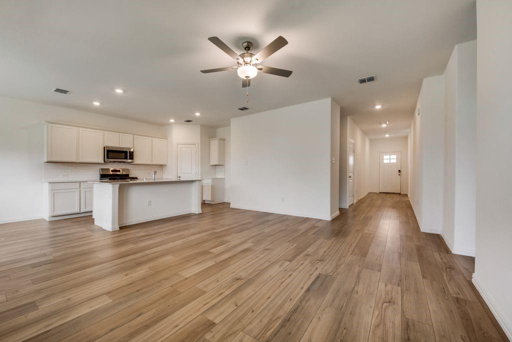 204 Coconut Drive Azle, TX 76020 - Photo 7 of 20 a view of a kitchen with wooden floor and a ceiling fan