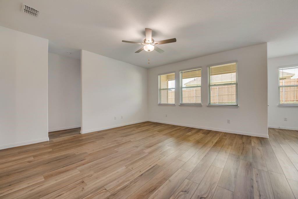 204 Coconut Drive Azle, TX 76020 - Photo 8 of 20 a view of an empty room with wooden floor and a window