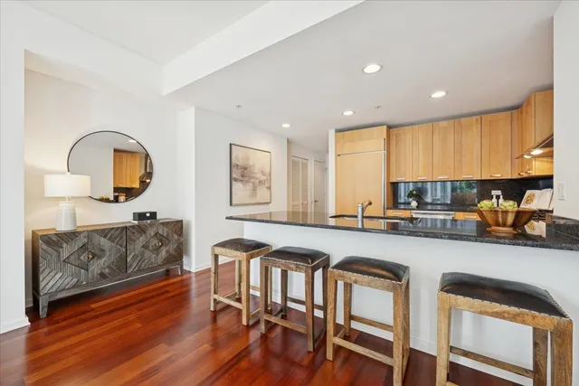 a large kitchen with a table chairs wooden floors and a view of living room