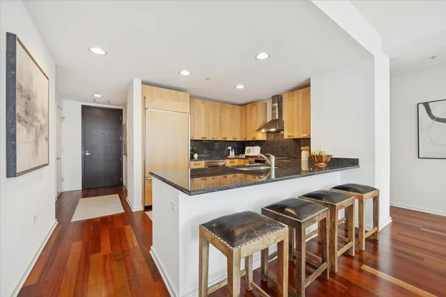 a kitchen with stainless steel appliances granite countertop a stove top oven a sink and a refrigerator