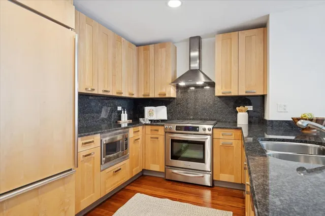 a kitchen with stainless steel appliances granite countertop a stove a sink and a microwave